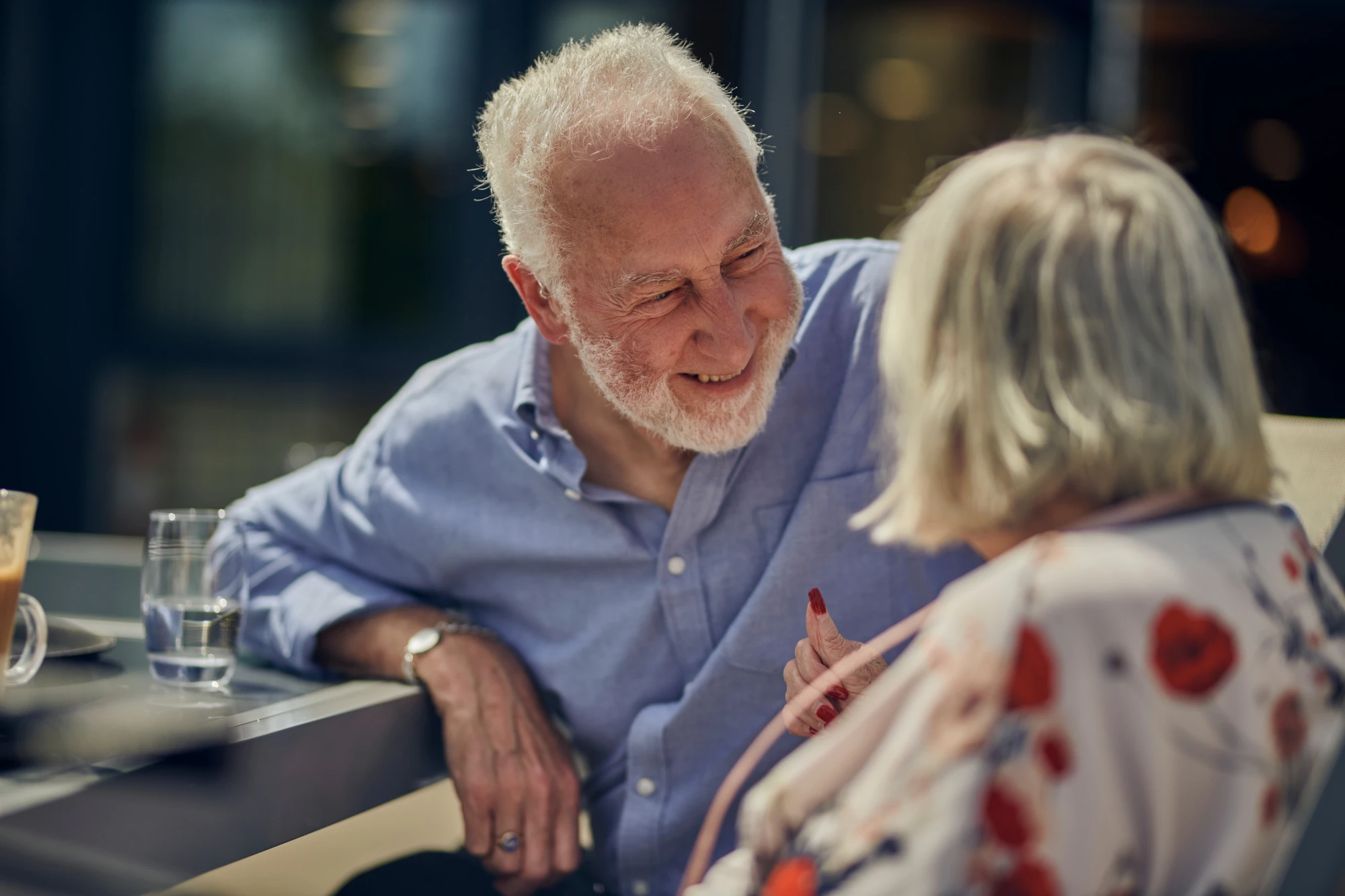 Smiling older man sitting with older woman in the sunshine