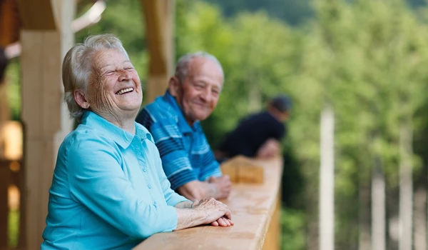 Older Man And Woman Smiling And Laughing On Balcony