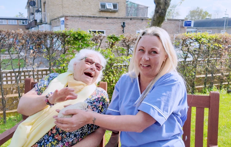 Staff And Resident Laughing With A Little Hedgehog