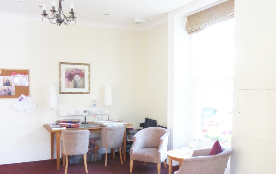 A seating area and desk with a pink carpet in a white room at Ing Royde,