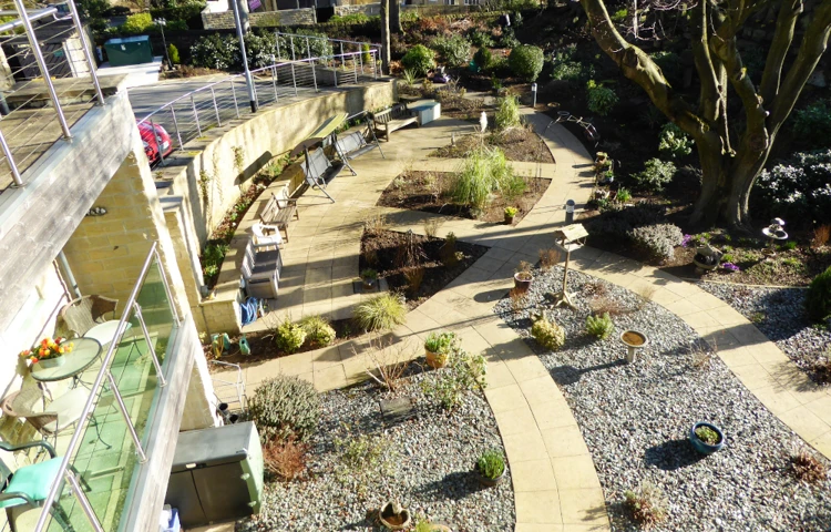 Outside view pebbled garden with shrubs and pots for residents of Ing Royde to enjoy