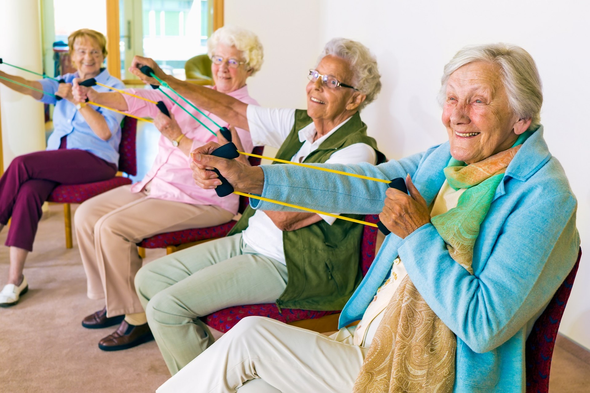 senior citizens participating in a low-impact chair aerobics class