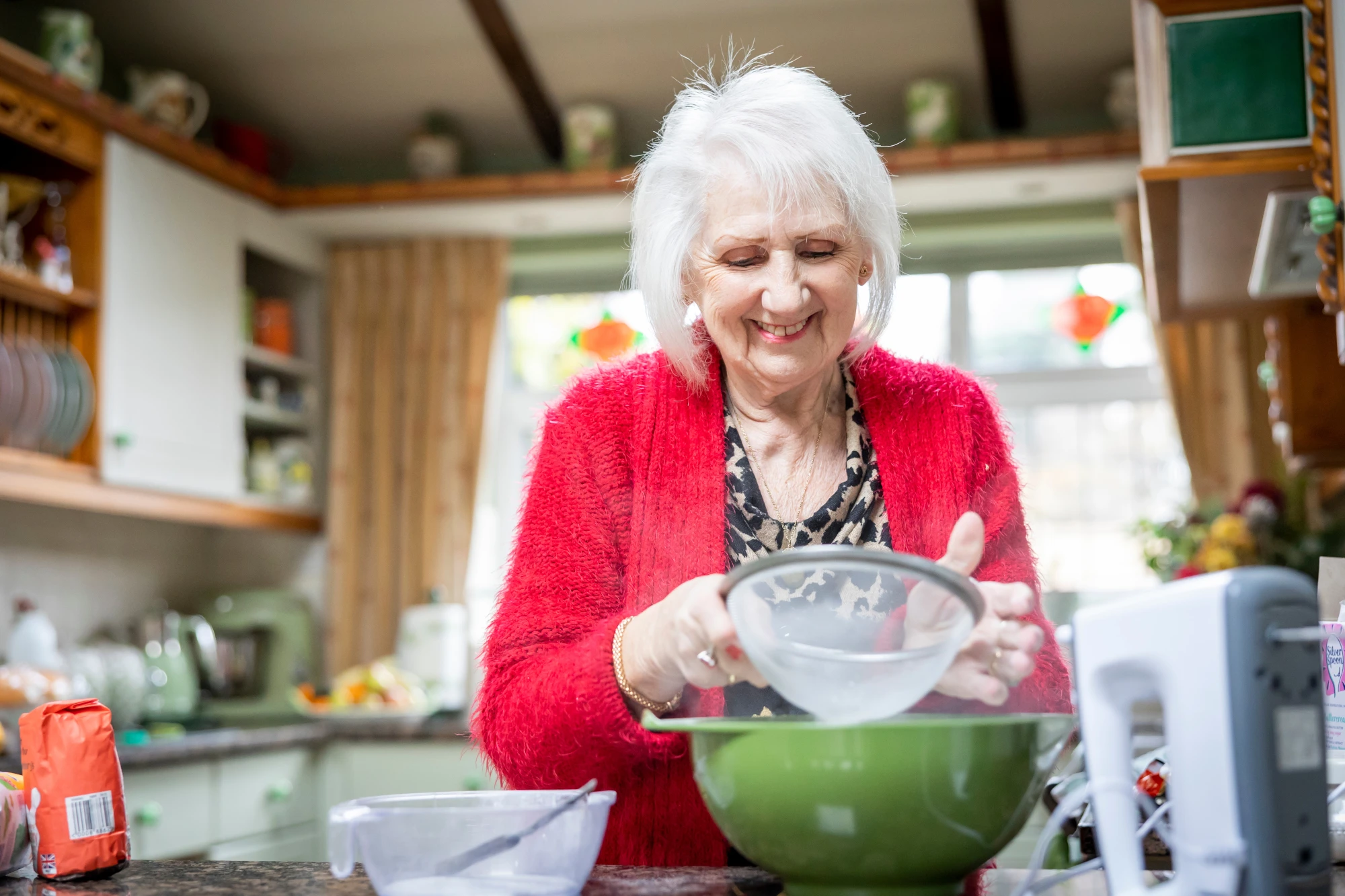 Smiling older woman doing some baking in her kitchen