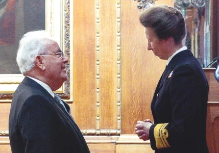 Michael receiving MBE from Princess Anne